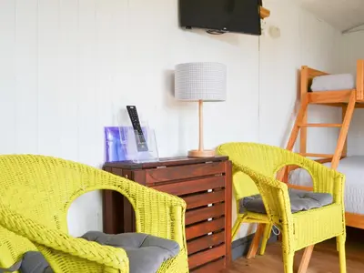 two yellow wicker chairs sitting next to a wooden dresser at Ryan's Shepherd Hut - Uk43565 in Bowness-on-Solway