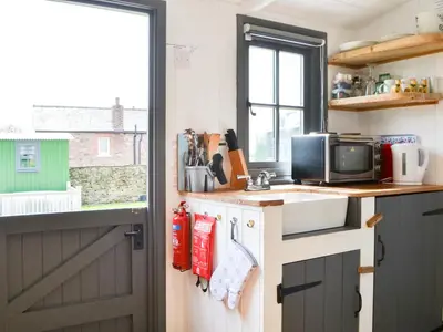a small kitchen with a sink and a window at Ryan's Shepherd Hut - Uk43565 in Bowness-on-Solway