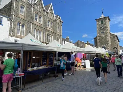 a group of people walking around a market with tents at Stanleys Sanctuary, Lake District in Plumbland