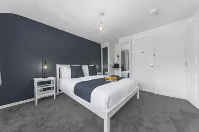 a bedroom with a large bed with a blue wall at Brundholme House in Keswick