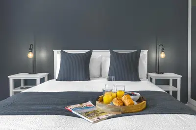 a tray of food on a bed with drinks and bread at Brundholme House in Keswick
