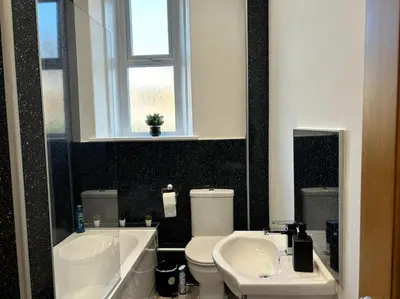 a bathroom with two sinks and a toilet and a window at Harbour cottage Annan in Annan