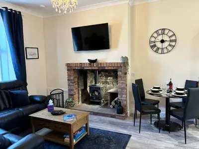 a living room with a fireplace and a tv on the wall at Harbour cottage Annan in Annan