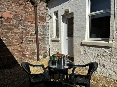 a small table with four chairs and a window at Quay cottage Annan in Annan