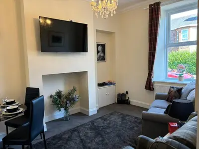 a living room with a fireplace with a tv on the wall at Quay cottage Annan in Annan