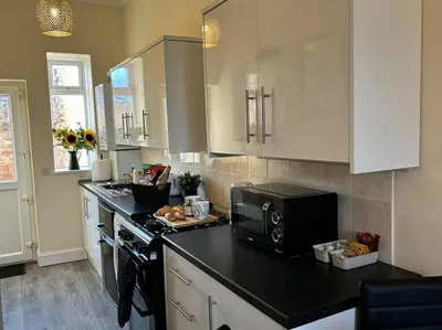 a kitchen with a black counter top and a microwave at Quay cottage Annan in Annan