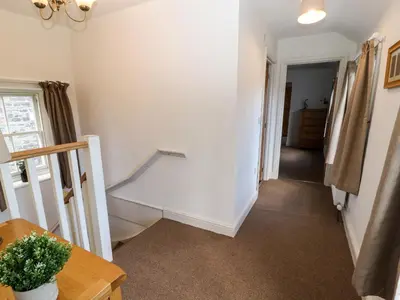 a hallway with white walls and a stair case at Holborn Cottage, Blencathra Street in Keswick