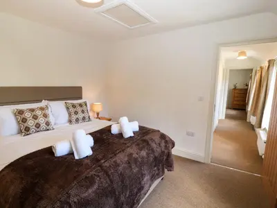 a bedroom with a large bed with two pillows at Holborn Cottage, Blencathra Street in Keswick