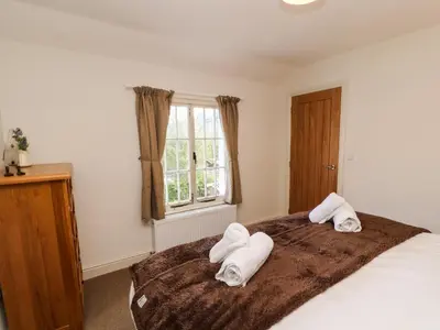 a bedroom with a bed with towels on it at Holborn Cottage, Blencathra Street in Keswick