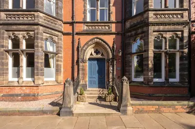 a brick building with a blue door and stairs at Host & Stay - Chatsworth Townhouse I in Carlisle