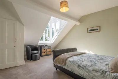 a attic bedroom with a bed and a chair at Host & Stay - Chatsworth Townhouse II in Carlisle