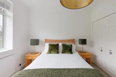 a bedroom with a large bed with two lamps at The Paddock at Brickrow Farm in Ayr