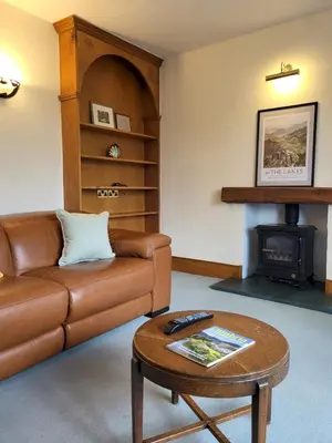 a living room with a leather couch and a coffee table at Wheelwrights House in Ambleside