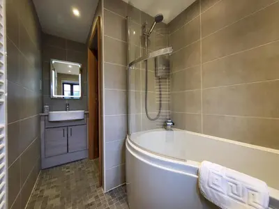 a bathroom with a tub and a sink at Wheelwrights House in Ambleside