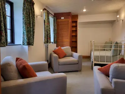 a living room with two couches and a bed at Wheelwrights House in Ambleside