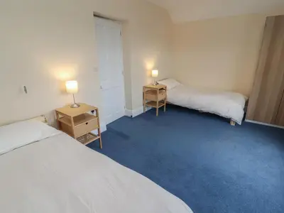 a room with two beds and two lamps on tables at Burnbank in Maryport
