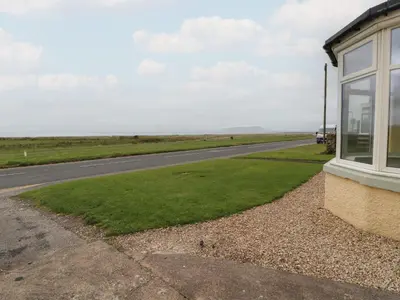 a building with a window next to a road at Burnbank in Maryport