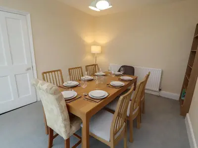 a dining room with a wooden table and chairs at Burnbank in Maryport