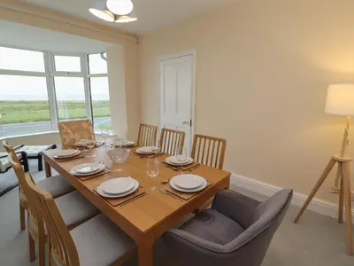 a dining room with a wooden table and chairs at Burnbank in Maryport