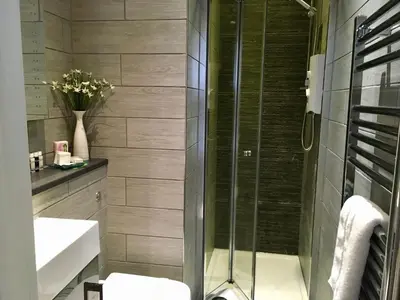 a bathroom with a shower and a toilet and a sink at Cartref Guest House in Carlisle