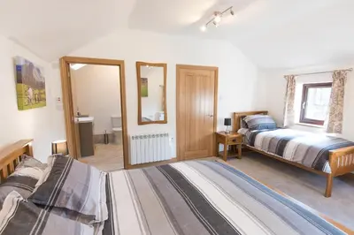 a bedroom with two beds and a mirror at Crookabeck B&B in Patterdale