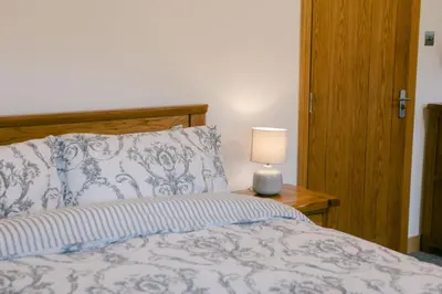 a bedroom with a bed with a lamp on a table at Crookabeck B&B in Patterdale