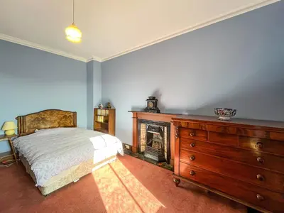 a bedroom with a bed and a fireplace and a dresser at Kirkdale in Kirkton