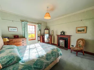 a bedroom with a bed and a fireplace at Kirkdale in Kirkton