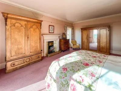 a bedroom with a large bed and a fireplace at Kirkdale in Kirkton