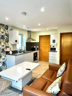 a living room with a couch and a table in a kitchen at The Anne'x in Dalbeattie