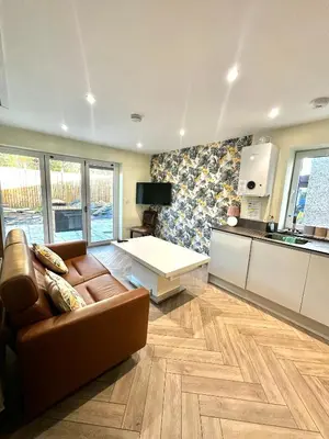 a living room with a couch and a kitchen at The Anne'x in Dalbeattie