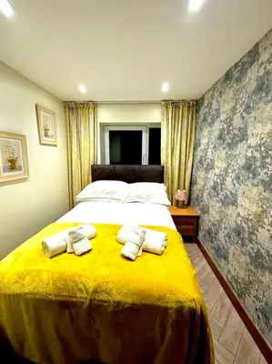 a bedroom with a large bed with towels on it at The Anne'x in Dalbeattie