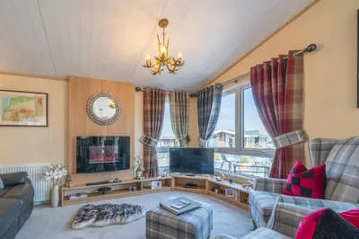 a living room with a couch and a tv at Antler Lodge - Meadows Retreat Lodge Park in Plumbland