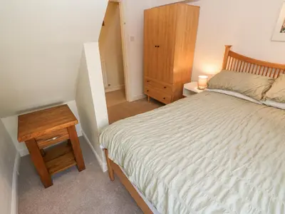 a small bedroom with a bed and a night stand at John Duftons Barn in Cockermouth