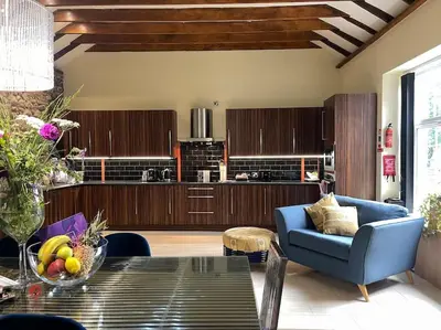 a living room with a table and a blue couch at WestLaigh Central Scotland with outdoor BBQ Hut, pets welcome in Strathaven
