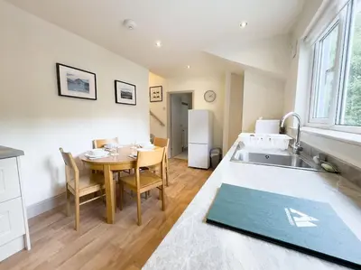 a kitchen and dining room with a table and a sink at RIDGEMOUNT APT - Great base for walking and cycling in Keswick, Lake District National Park in Keswick