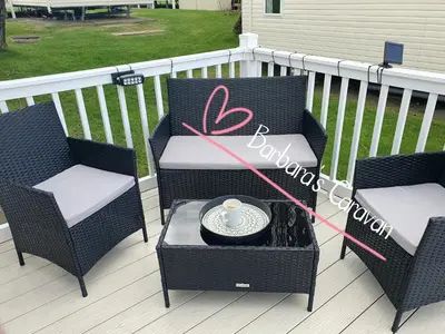 two chairs and a table on a deck at Barbara's Caravan Craig Tara in Ayr