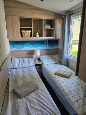 a small room with two beds in a caravan at Barbara's Caravan Craig Tara in Ayr