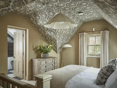 a bedroom with a large bed with a patterned ceiling at Eskdale Retreat in Holmrook