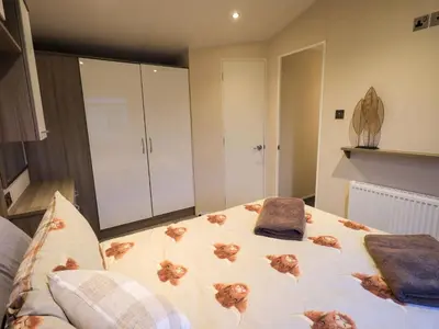 a bedroom with a large bed with two pillows on it at Highlands Way Lodge in Workington