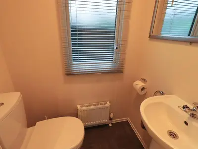 a bathroom with a white toilet and a sink at Highlands Way Lodge in Workington