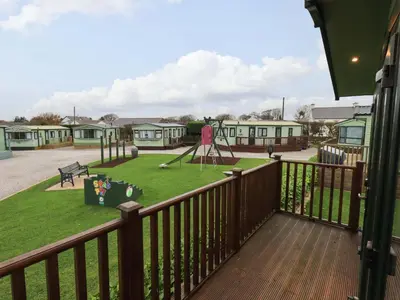 a view from the balcony of a park with a playground at Highlands Way Lodge in Workington