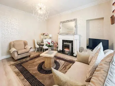 a living room with a couch and a fireplace at Beachcomber Apartment in Girvan