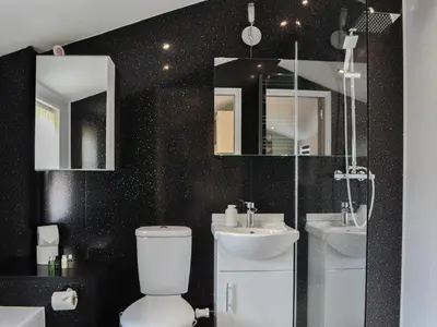 a bathroom with a toilet and a sink and mirror at Tiberius Claudius Augustus Suite - Uk43559 in Bowness-on-Solway
