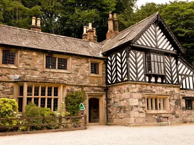an old stone house with a black and white building at YHA Wasdale Hall in Nether Wasdale