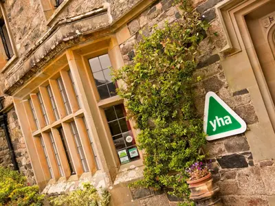 a sign on the side of a building with plants at YHA Wasdale Hall in Nether Wasdale