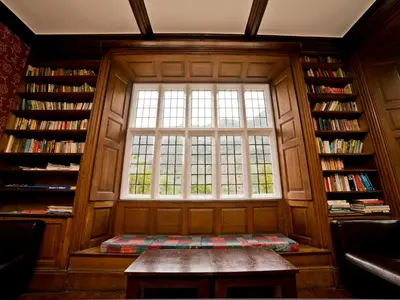 a window in a library with a table in front at YHA Wasdale Hall in Nether Wasdale