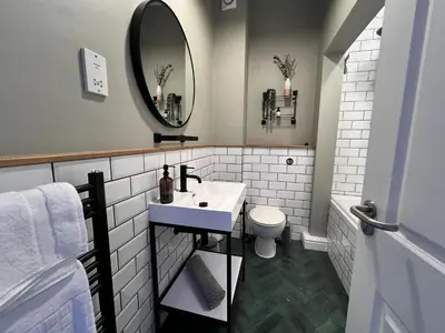 a white bathroom with a sink and a mirror at The Tops in Keswick