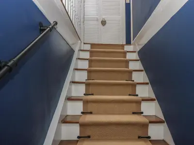 a set of stairs with a blue wall at Benstead Cottage in Seascale