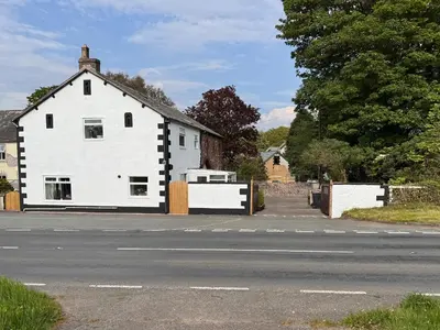 a white house sitting on the side of a street at Benstead Cottage in Seascale